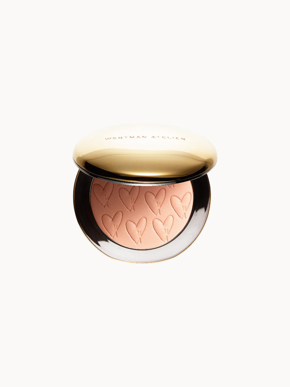 Geöffnete Puderdose mit goldenem Deckel und geprägtem Schriftzug „Westman Atelier“; innen ein bronzefarbener Puder mit Herzprägung.