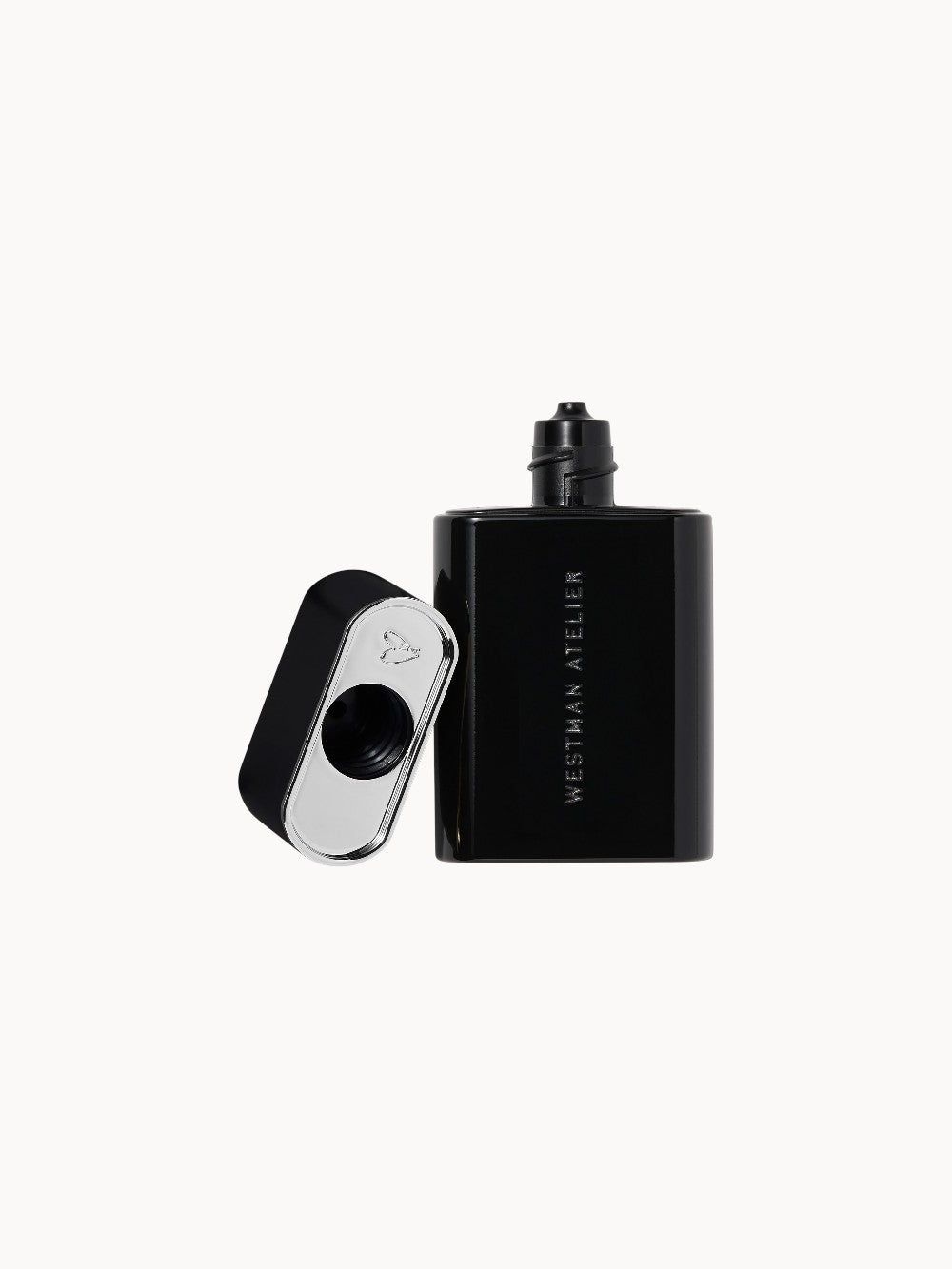 Schwarze, rechteckige Flasche mit silbernem Deckel und Pumpaufsatz, Produkt von Westman Atelier, aufgenommen vor weißem Hintergrund.