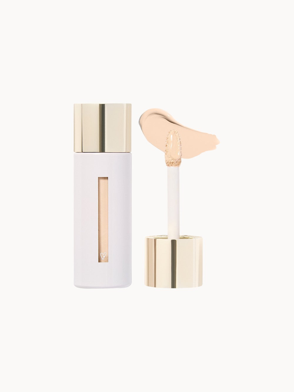 Flüssigconcealer von Westman Atelier in hellem Farbton, mit gold-weißer Verpackung und Applikator mit beige-cremiger Textur.