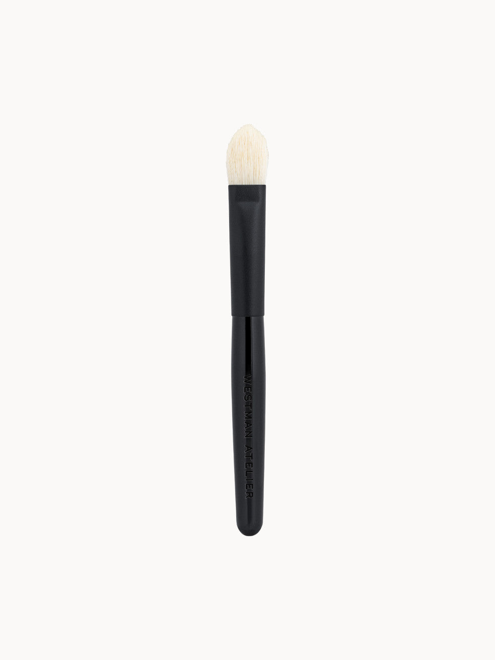 Lidschattenpinsel Eye Shadow I von Westman Atelier – flacher, konisch geformter Make-up-Pinsel mit kurzem, schwarzem Griff und feinen, hellen Borsten.