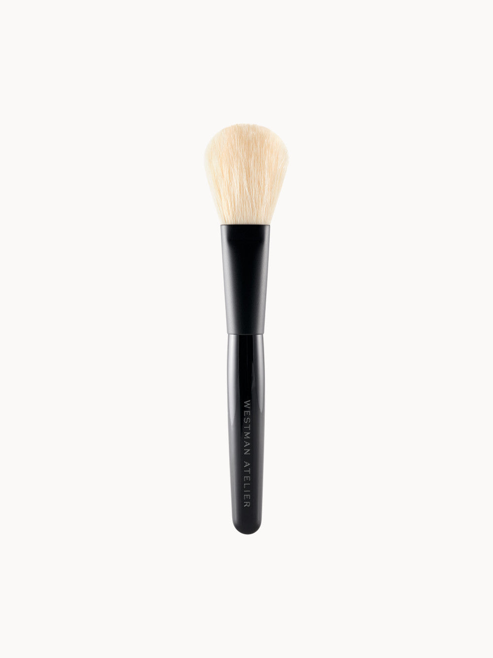 Puderpinsel von Westman Atelier – eleganter Make-up-Pinsel mit schwarzem Griff und weichen, oval geformten, hellen Borsten.